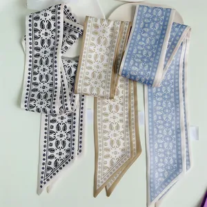 Detailed view of paisley and geometric pattern long silk ribbons with stitching detail