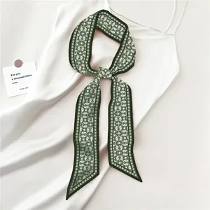 Detailed macro view of deep green paisley twilly scarf with a silky satin texture