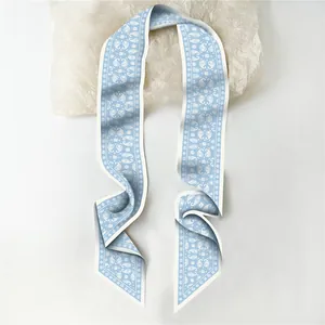 Macro detail of paisley pattern on blue and white silk twilly scarf with pointed ends