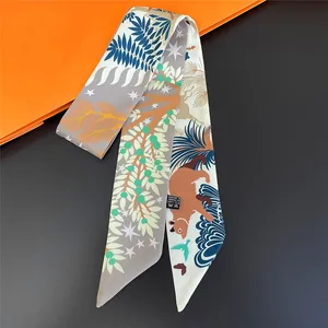 Detail of artistic jungle animal print twilly scarf with blue leaves and a brown bear