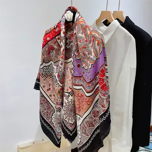 Detail der lebhaften Blumenmuster auf einem 130cm Seidenschal über einem schwarzen Blazer