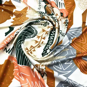 Macro view of spiral folded hand-painted floral silk scarf with vibrant botanical print