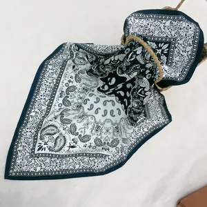 Blue paisley silk scarf with vintage bandana pattern styled next to a straw basket