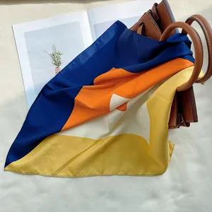 Gros plan d'un foulard en soie aux motifs géométriques sur un sac à main en cuir