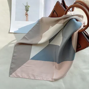 Détail du foulard en satin de 53cm avec motifs géométriques sur sac en cuir
