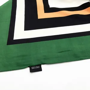 Detail of 100% silk scarf showing geometric floral pattern and authentic fabric care label