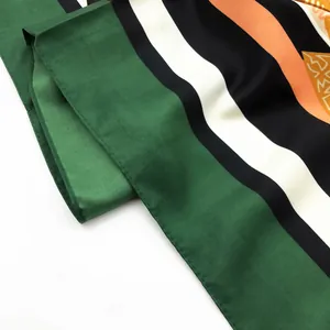 Detail of hand-painted floral silk scarf showing fine edge stitching and fabric texture