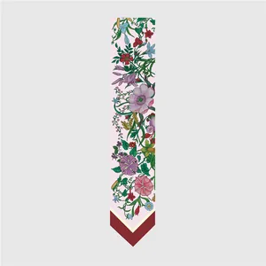 Detalle del estampado floral y puntas de un pañuelo de seda rosa elegante para mujer