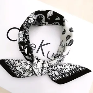 Detail of a silk paisley square scarf tied in a ring knot with a black and white geometric border