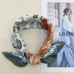 Detailed view of silk-like paisley pattern scarf with elegant navy and caramel accents