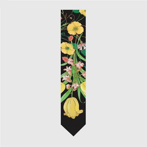 Detalle de un pañuelo de seda negra con vibrantes motivos florales amarillos y naranjas