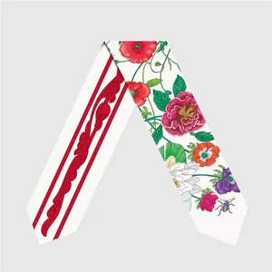 Detalle de un pañuelo de seda con estampados florales, mariquitas y bordes rojos