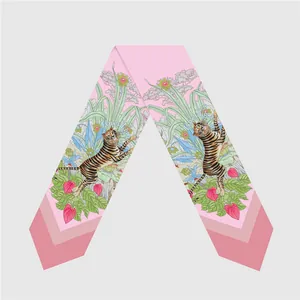 Detalle de pañuelo de seda rosa con ilustraciones de tigre y flores tropicales
