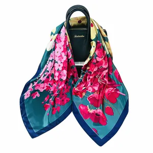 Elegante foulard in seta da 90cm con motivi floreali drappeggiato su borsa in pelle nera