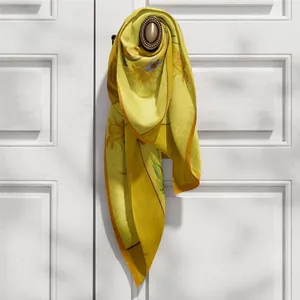 Écharpe en soie motif Tournesols de Van Gogh, drapée élégamment sur une poignée de porte
