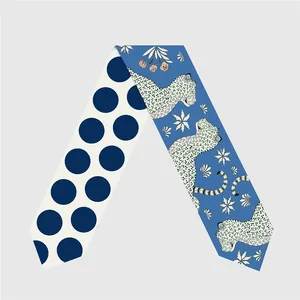 Primer plano de un pañuelo twilly de doble cara con estampados de leopardo y flores