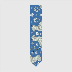 Vista detallada de bufanda de seda azul twilly con estampados de leopardo y flores