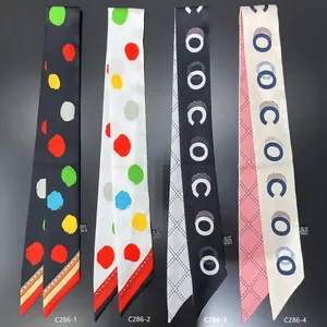 Detailed view of four narrow silk scarves featuring polka dots and geometric patterns