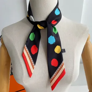 Detailed view of colorful polka dot pattern and stripe borders on silk neck scarf