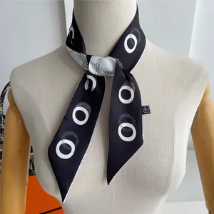 Detailed view of polka dot twilly scarf tied on neck with elegant black and white pattern