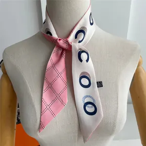 Detail of pink and beige twilly scarf with geometric patterns and polyester fabric texture