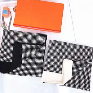 Classic houndstooth winter scarves in black and white with contrast borders shown from above