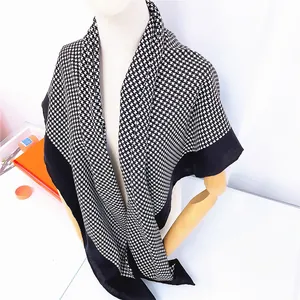 Close-up of black and white houndstooth scarf with wide black border on a mannequin