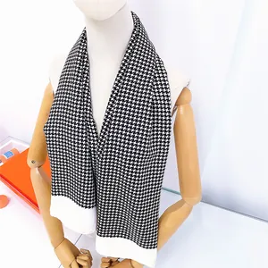Close-up of the black and white houndstooth scarf texture with a wide white hem design