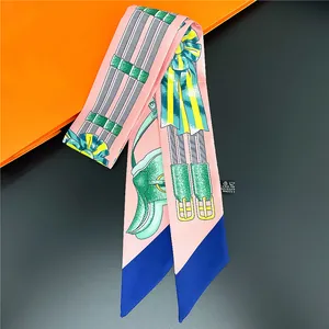 Roze satijnen Twilly-sjaal met kettingprint op een klassieke oranje geschenkdoos
