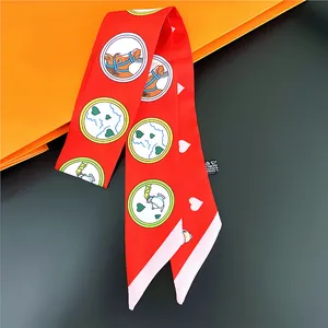 Détail d'un foulard Twilly rouge avec illustration de tête de cheval et motif de cœur