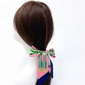 Roze zijden sjaal twilly als haarband met klassieke ketting- en stijgbeugelprint