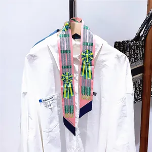 Detailopname van roze zijden twilly met vintage medailleprint geknoopt op een hemdskraag