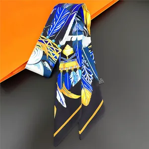 Foulard étroit à motif plumes noué sur une poignée avec un emballage cadeau orange vif