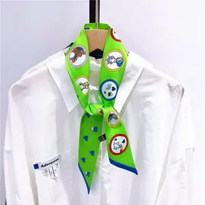 Détail d'un foulard en satin vert avec imprimé de conte de fées noué sur une chemise