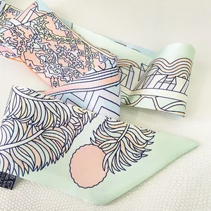Macro detail of twilly silk scarf showing feather floral patterns and twill fabric texture