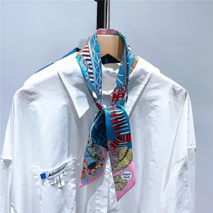 Close-up of floral twilly scarf with feather patterns tied on a white shirt collar