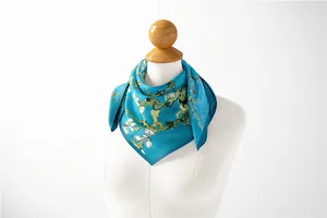 Detail view of Van Gogh's Almond Blossoms silk-like scarf tied on a white mannequin
