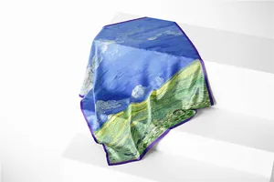 Detail view of Van Gogh oil painting scarf with vibrant green fields and purple rolled edges