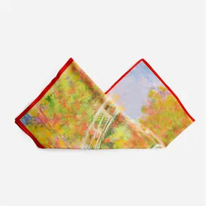 Detail of Monet Japanese Bridge silk scarf featuring artistic oil painting and red edges