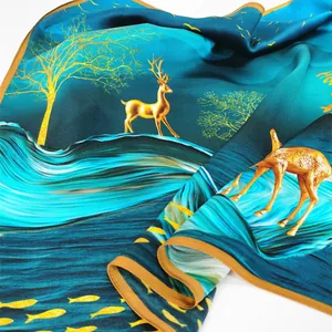Foulard en soie avec motifs de cerfs dorés et poissons sur fond bleu foncé et bleu-vert