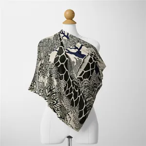 Dettaglio di un foulard in seta con stampa giraffa francese e fiori su un manichino bianco