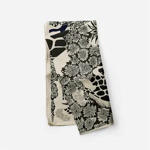 Dettaglio della stampa animalier giraffa e fiori su un foulard quadrato di seta