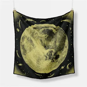 Detail of unicorn moon silk scarf with celestial star patterns hanging on a white wall