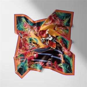 Dettaglio di un foulard di seta con testa di tigre e motivi a piume tropicali vivaci