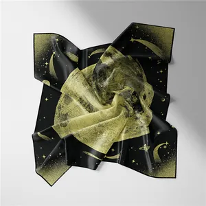 Detailed close-up of a premium black silk scarf with golden moon and star patterns