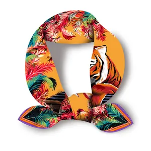 Dettaglio macro del foulard in seta con testa di tigre e motivi di piume tropicali