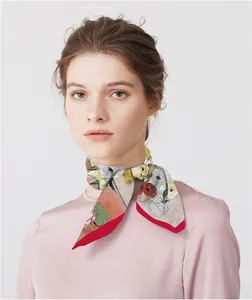 Sciarpa in seta con stampa pittura floreale e bordo rosso indossata da una modella