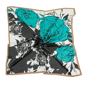 Detail view of large silk scarf featuring hand-painted blue rose patterns on monochrome fabric