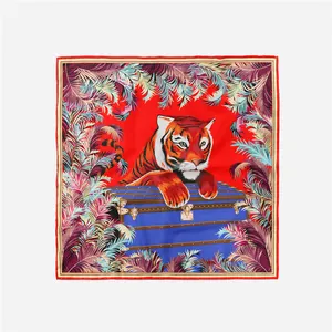 Dettaglio della stampa con tigre e foglie tropicali su sciarpa di seta quadrata rossa