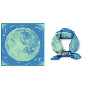 Detail of silk scarf featuring moon, stars, and pegasus prints in a blue gradient